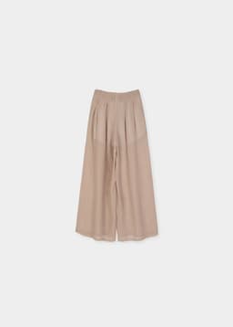 Detalle de pinzas en pantalón palazzo beige por detras